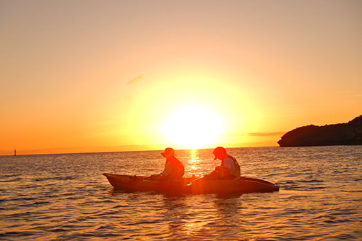 夕陽連結著大海與天空的日落獨木舟